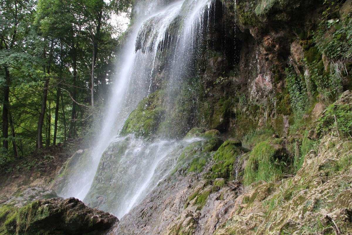 Der Bad Uracher Wasserfall stürzt sich den Hang hinab, umgeben ist er von viel grünem Moos