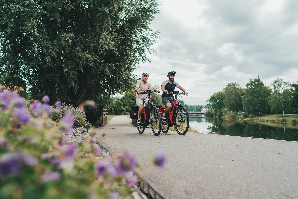 Fahrradfahrer fahren auf einem Radweg entlang der Donau